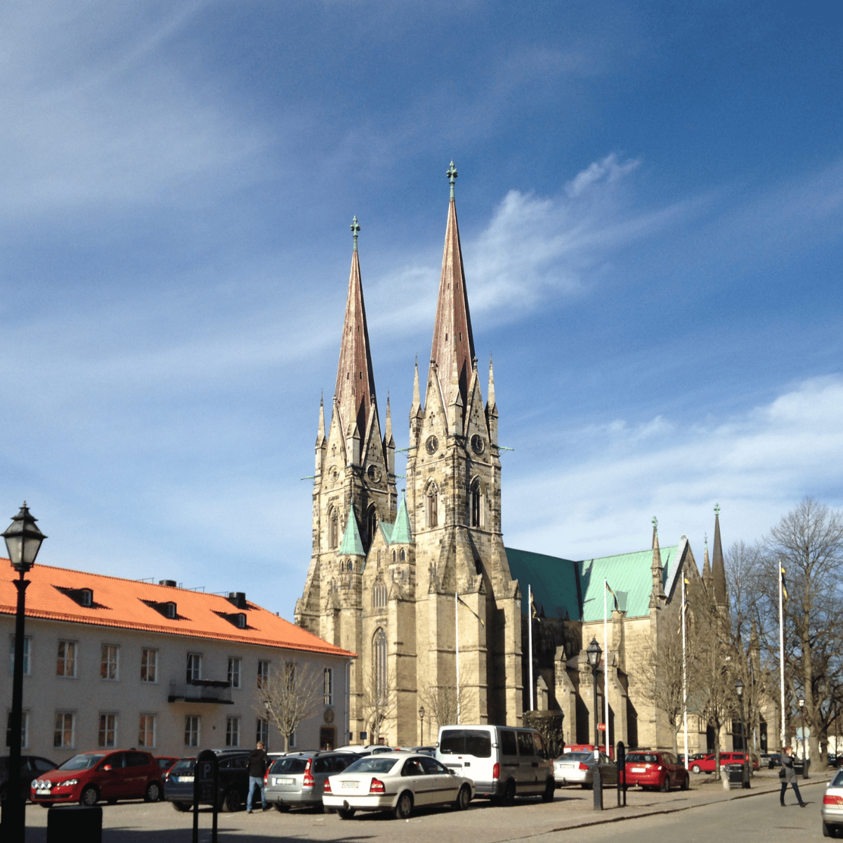 Skara domkyrka med öppen parkering för bilar framför sig utan garage med garageportar