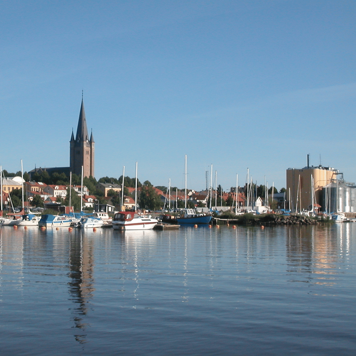 Skara domkyrka med öppen parkering för bilar framför sig utan garage med garageportar